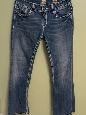 Studio 5 low rise bootcut jeans with white embroidered floral designs on back